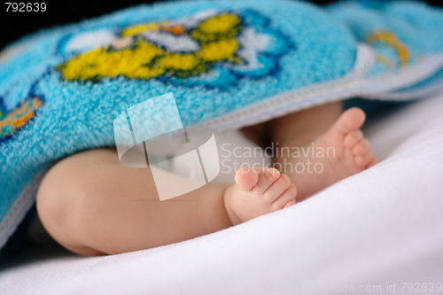 Image of Adorable toddler's feet on white bedsheet