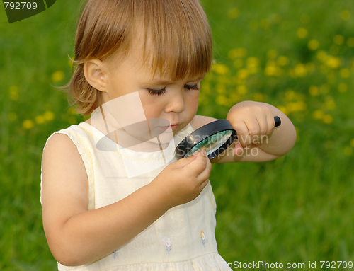 Image of Child looking at snail through magnifying glass