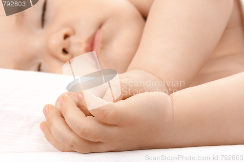 Image of Caucasian child asleep, clasping hands together