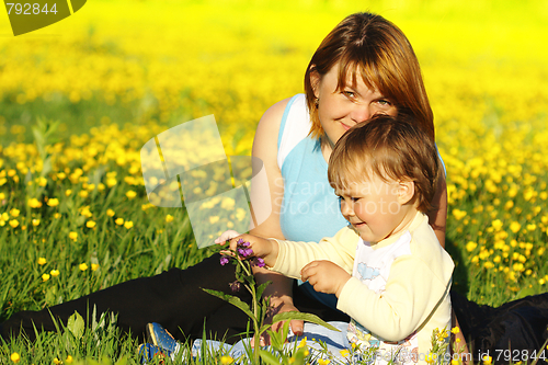 Image of Mother and her child play on meadow