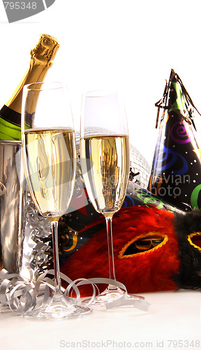 Image of Glasses of champagne with masks and party hats