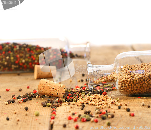 Image of Peppercorns in glass bottles on wood table