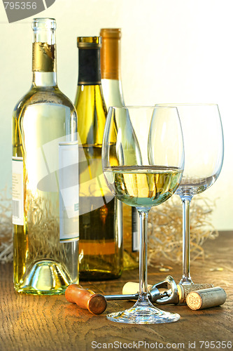 Image of Bottles of white wine with glasses 