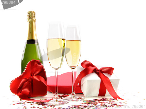 Image of Glasses of champagne with bottle and gifts 