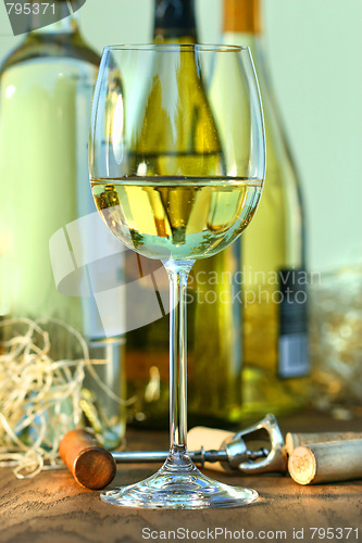 Image of Glass of white wine with bottles