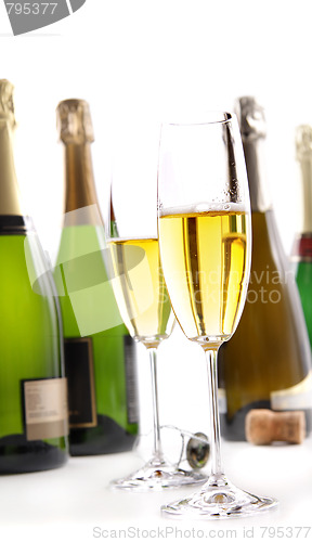 Image of Glasses of champagne with bottles on white