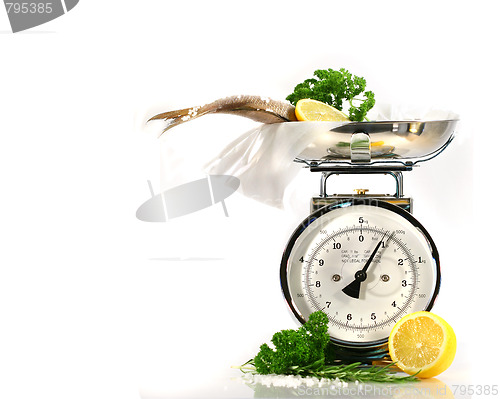 Image of Weight scale, fish,lemon on parchment paper 