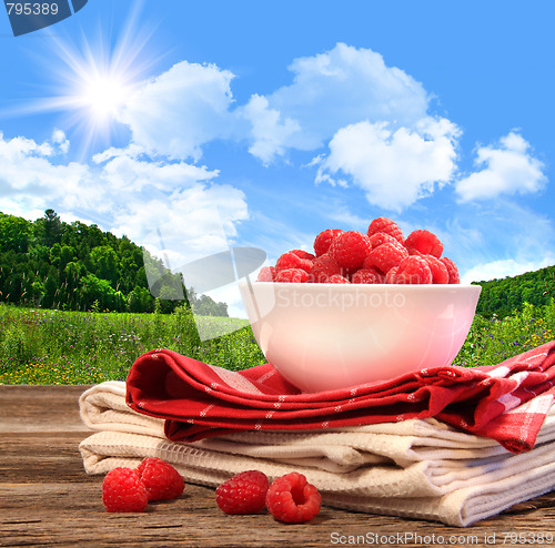 Image of Bowl of raspberries on rustic table 