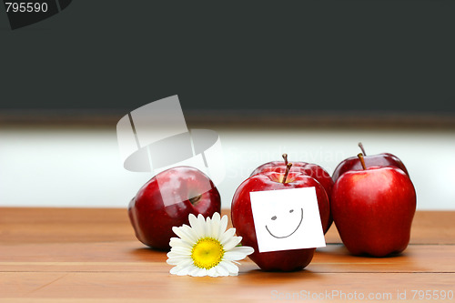 Image of Delicious red apples on desk with blackboard 