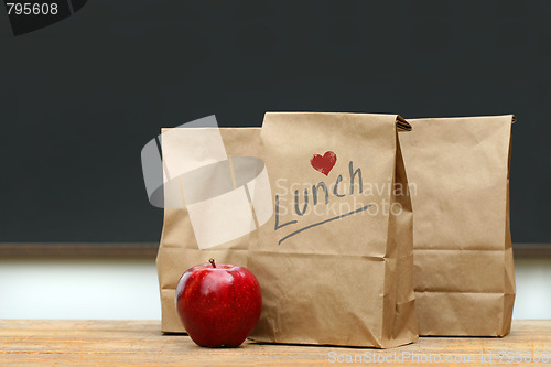 Image of Lunch bags with  apple on school desk