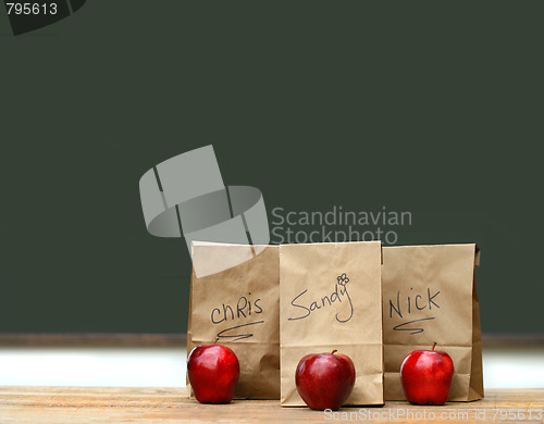 Image of Lunch bags on desk with red apples