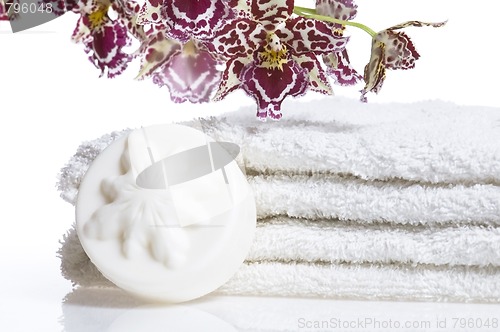 Image of Spa items with white towels, natural soap and orchid