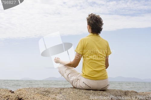 Image of Woman meditating at the sea