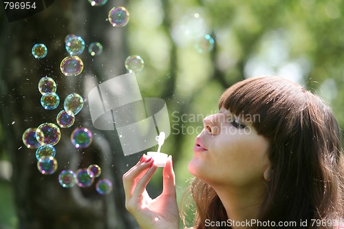 Image of girl blows soap bubbles