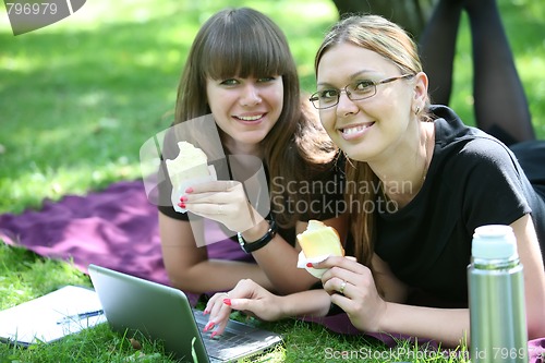 Image of two young businesswoman with laptop