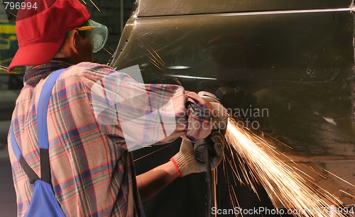 Image of worker cuts metal