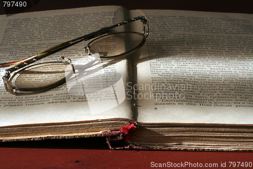 Image of aging book and spectacles for correcting the vision