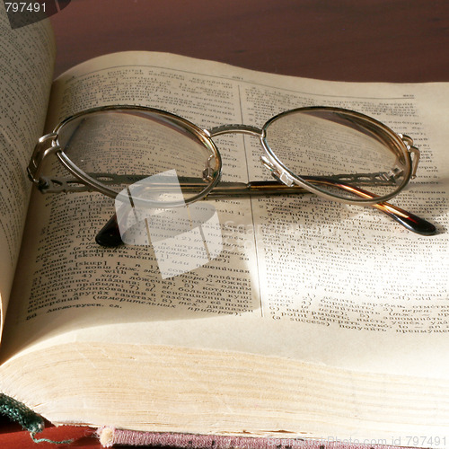 Image of aging book and spectacles for correcting the vision