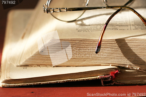 Image of aging book and spectacles for correcting the vision