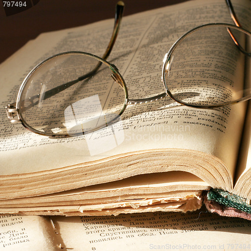 Image of aging book and spectacles for correcting the vision