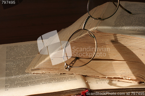 Image of aging book and spectacles for correcting the vision