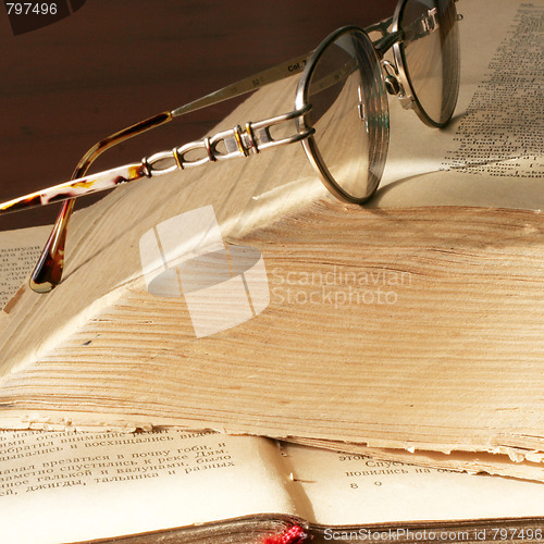 Image of aging book and spectacles for correcting the vision