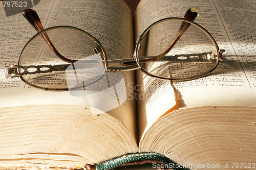Image of aging book and spectacles for correcting the vision