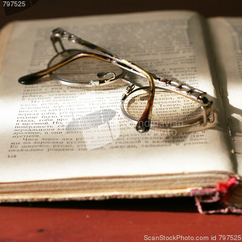 Image of aging book and spectacles for correcting the vision