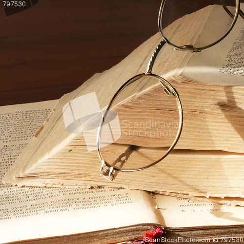 Image of aging book and spectacles for correcting the vision