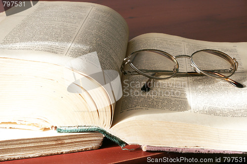 Image of aging book and spectacles for correcting the vision