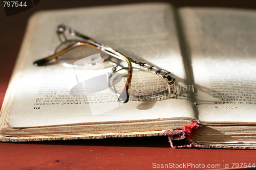 Image of aging book and spectacles for correcting the vision