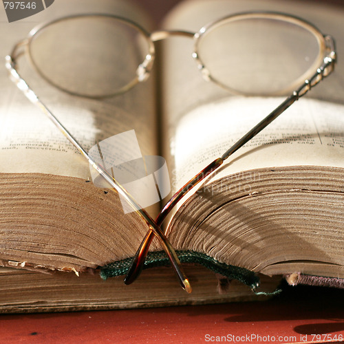 Image of aging book and spectacles for correcting the vision