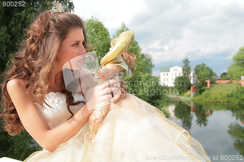 Image of beautiful princess looks at loved doll