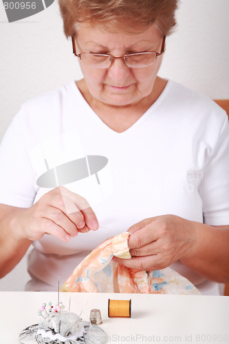 Image of Elderly woman sewing