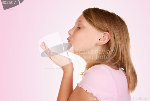 Image of young girl blowing a kiss on pink