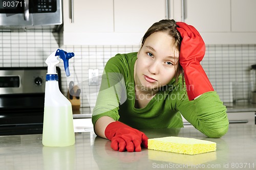 Image of Tired girl cleaning kitchen