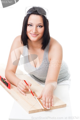 Image of Woman measuring wood plank