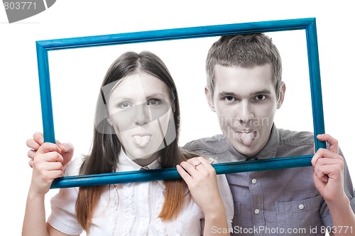 Image of Couple look from frame with stick out tongue