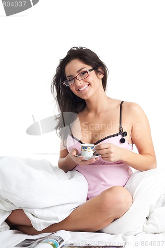 Image of Woman smile in bed drinking coffee