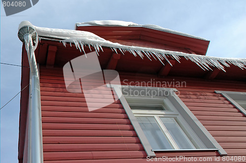 Image of Icicles hanging from roof on idyllic wood house