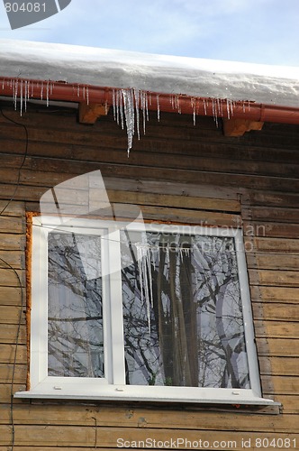 Image of Icicles hanging from roof on idyllic wood house