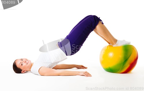 Image of Happy woman doing fitness exercises with ball