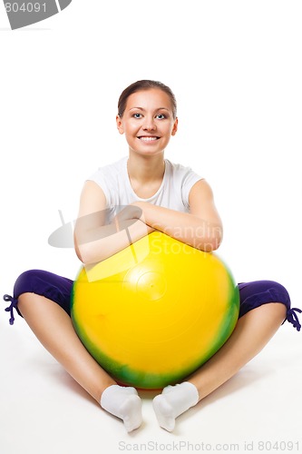 Image of Happy young woman sit with fitness ball