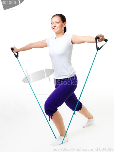 Image of Young woman doing fitness with expander