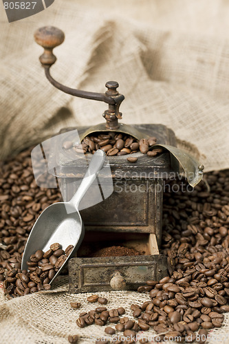 Image of Old coffee grinder with coffee beans
