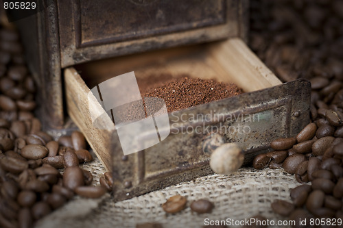 Image of Detail of an old coffee grinder with coffee beans