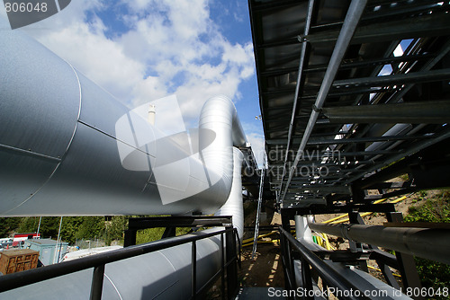 Image of  industrial pipelines on pipe-bridge against blue sky