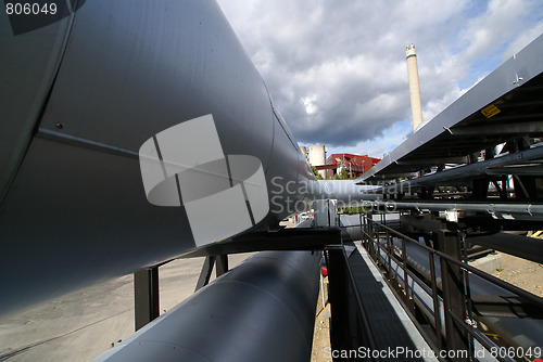 Image of industrial pipelines on pipe-bridge against blue sky