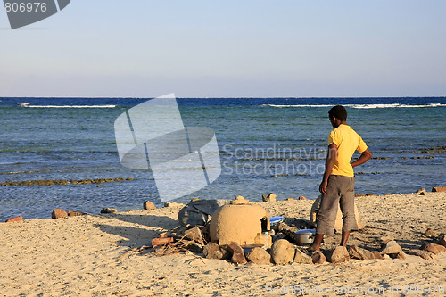 Image of Egyptian man cooking dinner on the beach