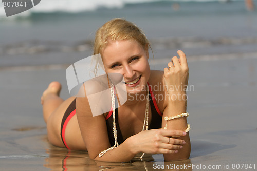 Image of good looking woman rolling around in the surf